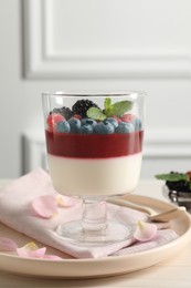 Delicious panna cotta with berries on light table Photo of Delicious panna cotta with berries on light table