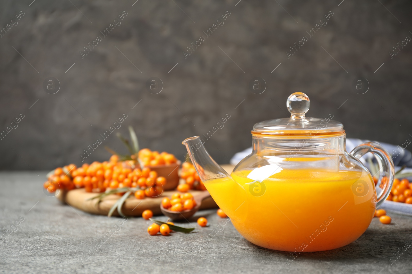 Delicious sea buckthorn tea and fresh berries on grey table. Space for text Photo of Delicious sea buckthorn tea and fresh berries on grey table. Space for text
