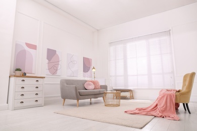 Stylish living room interior with comfortable sofa and beautiful pictures Photo of Stylish living room interior with comfortable sofa and beautiful pictures