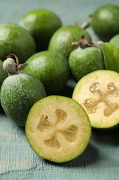 Fresh green feijoa fruits on blue wooden table, closeup Photo of Fresh green feijoa fruits on blue wooden table, closeup