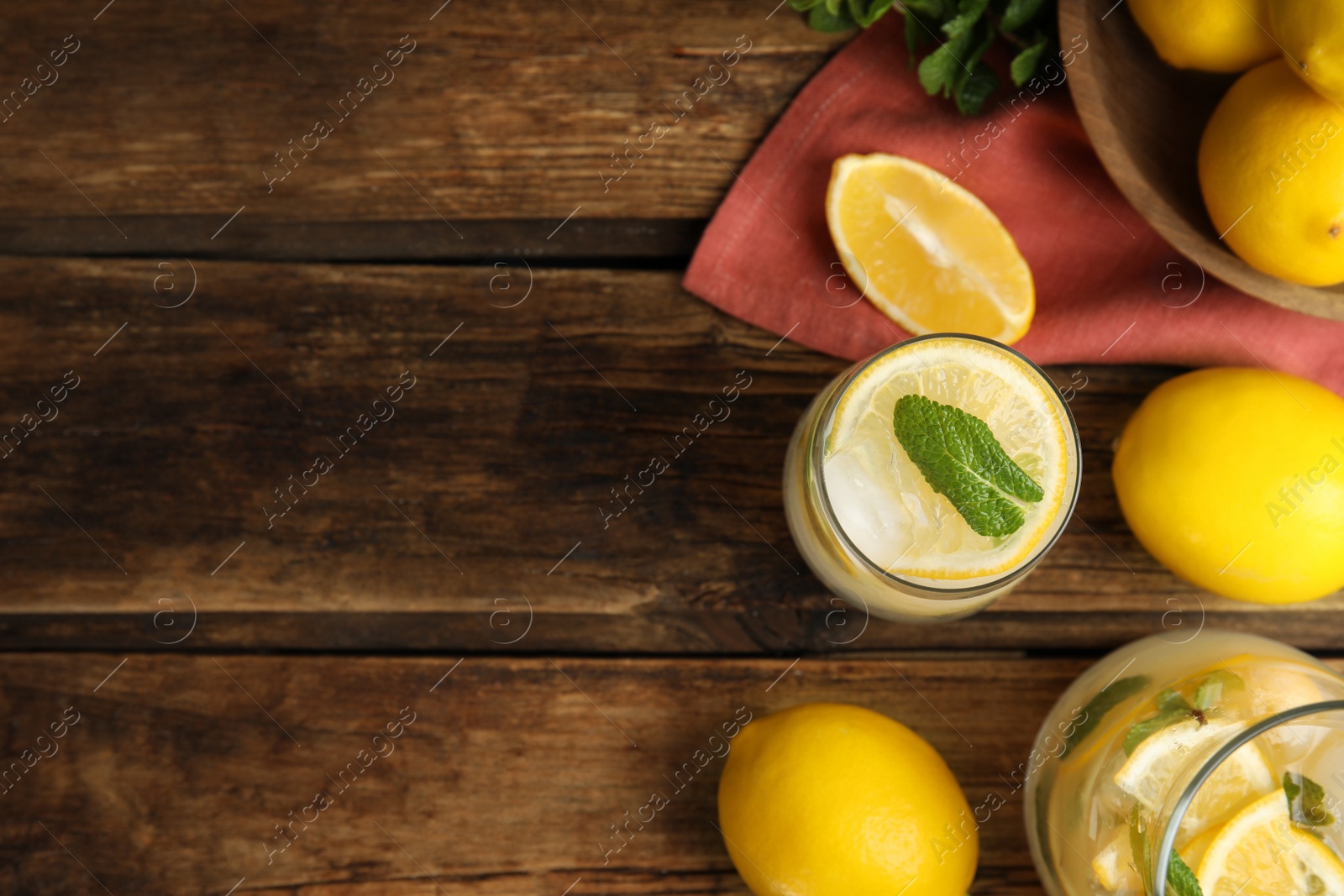 Photo of Cool freshly made lemonade and fruits on wooden table, flat lay. Space for text