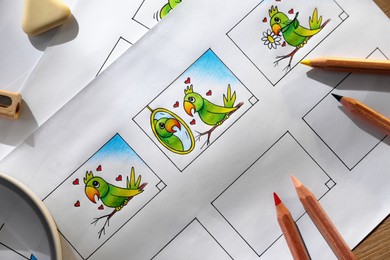 Storyboards with cartoon sketches at workplace, flat lay. Pre-production process Photo of Storyboards with cartoon sketches at workplace, flat lay. Pre-production process