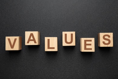 Wooden cubes with word VALUES on black background, flat lay Photo of Wooden cubes with word VALUES on black background, flat lay