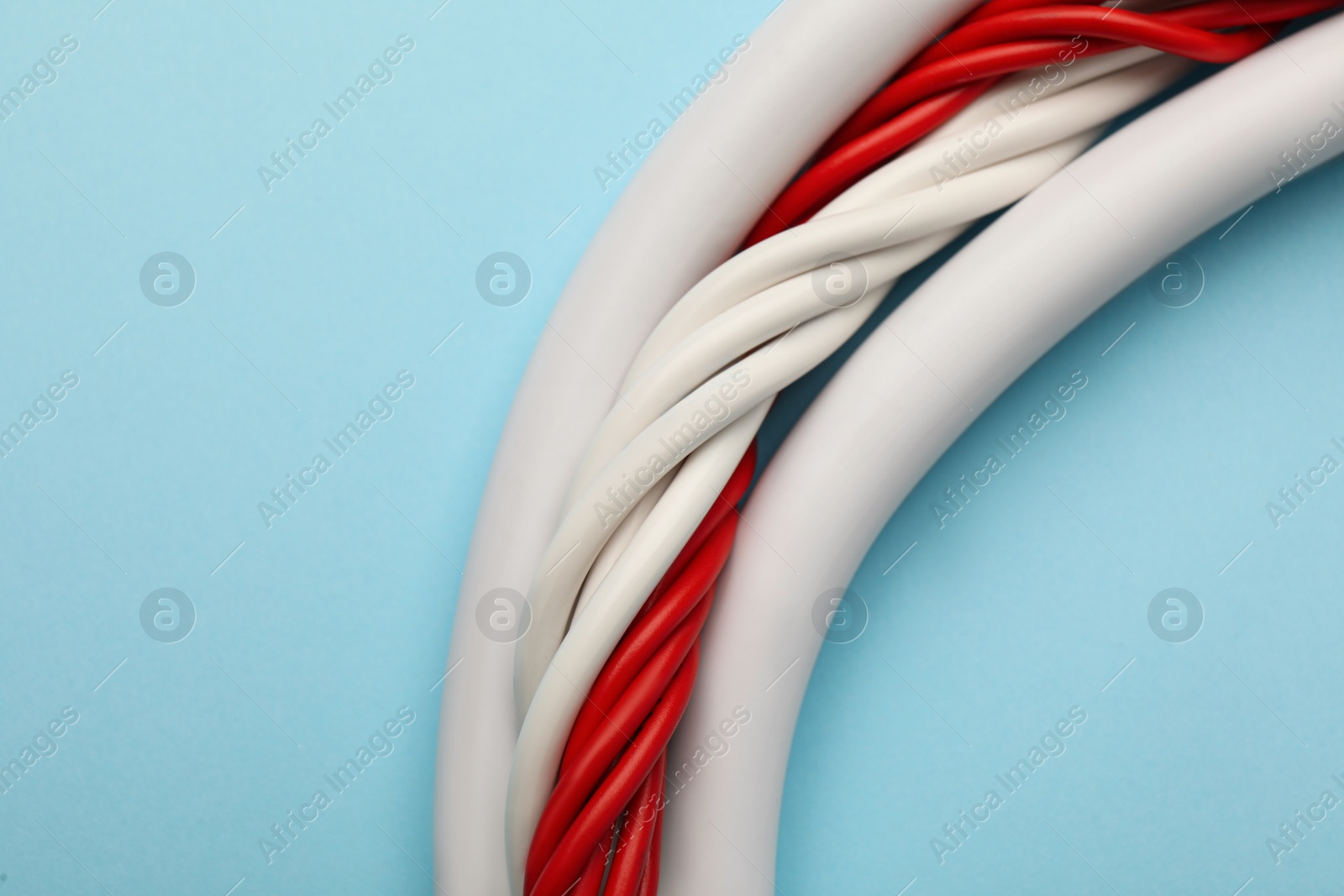 Many electrical cables on light blue background, closeup Photo of Many electrical cables on light blue background, closeup