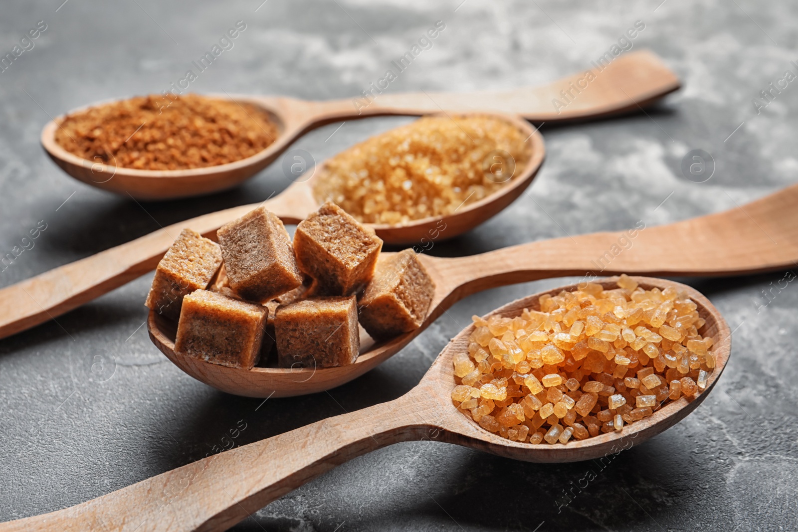 Spoons with brown sugar on table Photo of Spoons with brown sugar on table