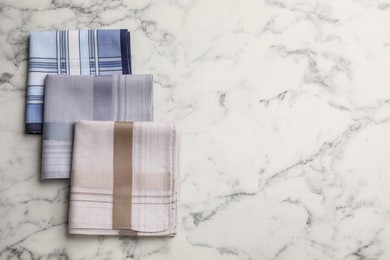 Different handkerchiefs folded on white marble table, flat lay. Space for text Photo of Different handkerchiefs folded on white marble table, flat lay. Space for text