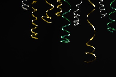 Many colorful serpentine streamers on black background Photo of Many colorful serpentine streamers on black background