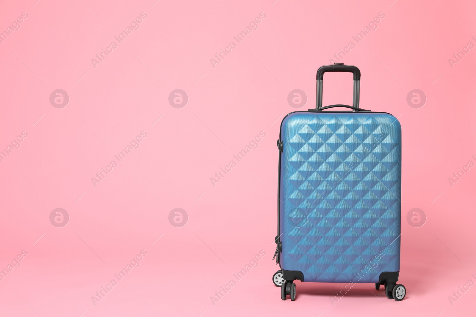 Photo of Stylish blue suitcase on pink background. Space for text
