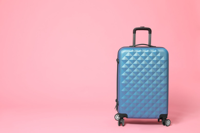 Stylish blue suitcase on pink background. Space for text Photo of Stylish blue suitcase on pink background. Space for text