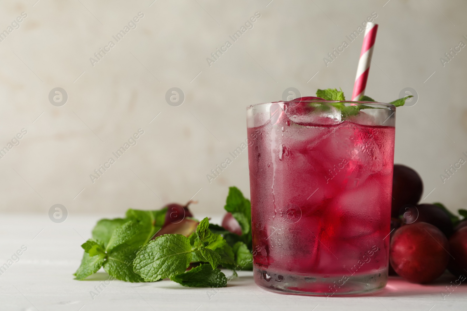 Delicious grape soda water with mint on white table. Refreshing drink Photo of Delicious grape soda water with mint on white table. Refreshing drink