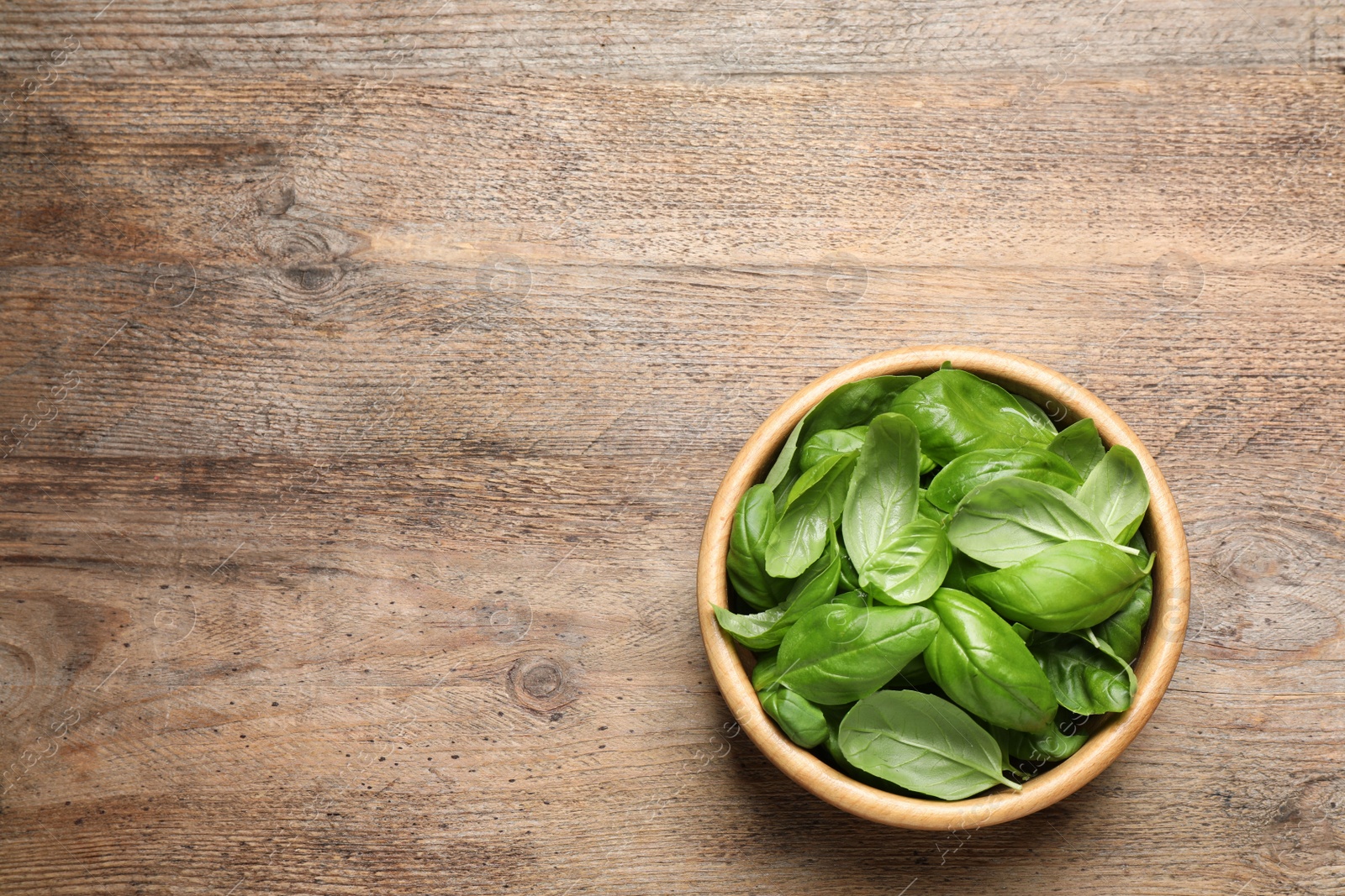 Fresh basil on wooden table, top view. Space for text Photo of Fresh basil on wooden table, top view. Space for text