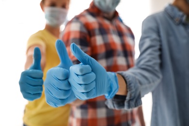 Group of people in blue medical gloves showing thumbs up on blurred background, closeup Photo of Group of people in blue medical gloves showing thumbs up on blurred background, closeup