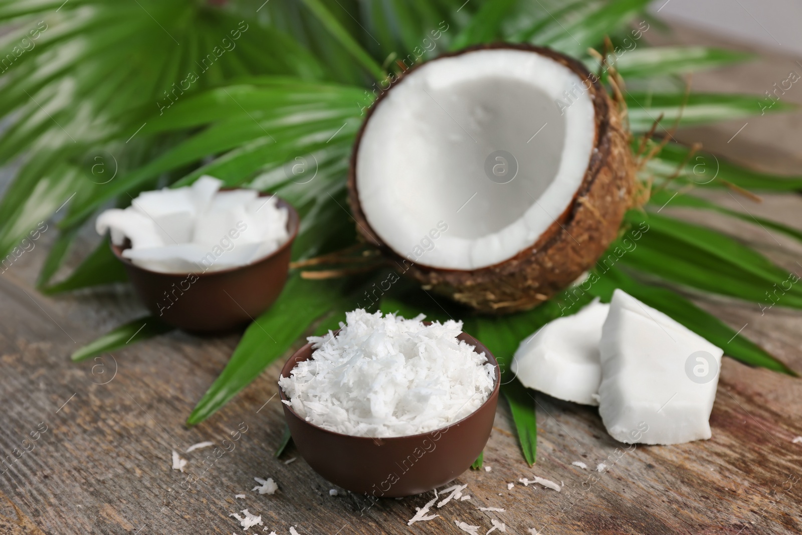 Bowl with fresh coconut flakes on wooden background Photo of Bowl with fresh coconut flakes on wooden background