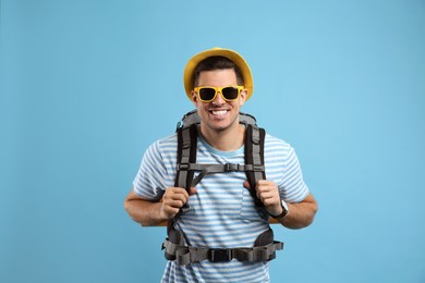 Male tourist with travel backpack on turquoise background Photo of Male tourist with travel backpack on turquoise background