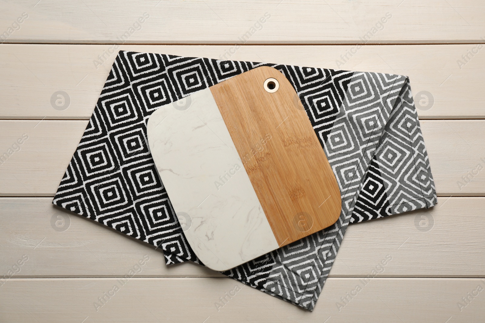 Kitchen towel and cutting board on white wooden table, top view Photo of Kitchen towel and cutting board on white wooden table, top view
