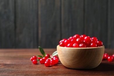 Tasty ripe cranberries on brown wooden table, closeup. Space for text Photo of Tasty ripe cranberries on brown wooden table, closeup. Space for text