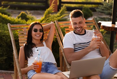 Happy couple with laptop resting together outdoors Image of Happy couple with laptop resting together outdoors
