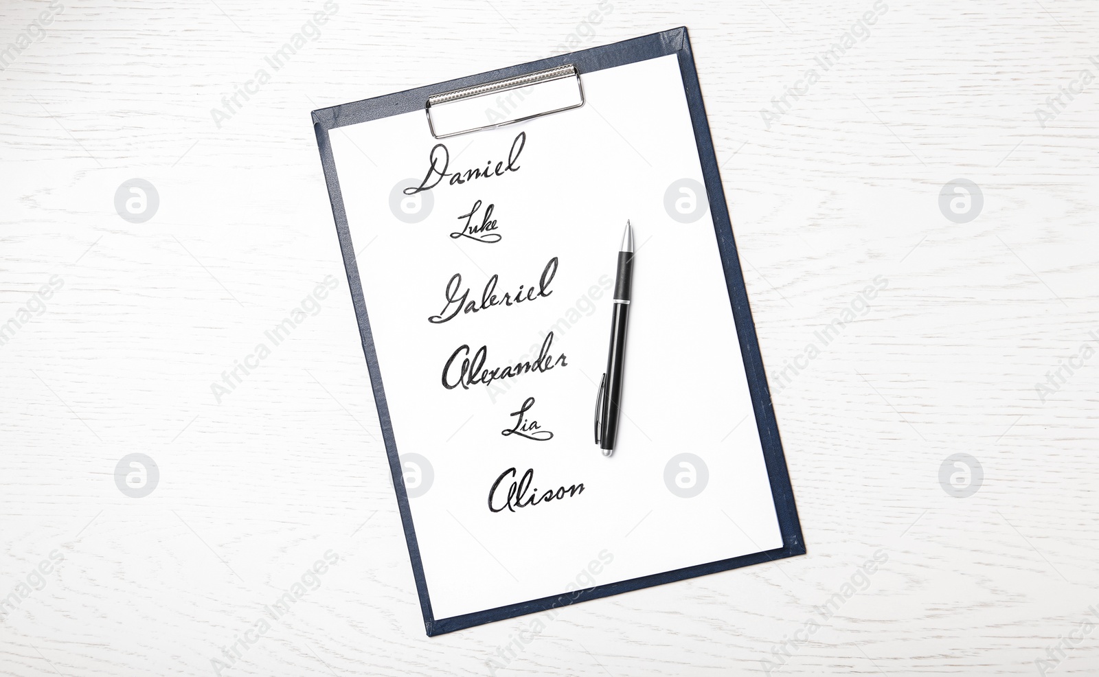 Clipboard with written different baby names and pen on white wooden table, top view Photo of Clipboard with written different baby names and pen on white wooden table, top view