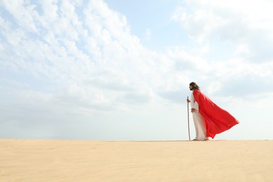 Jesus Christ walking with stick in desert. Space for text Photo of Jesus Christ walking with stick in desert. Space for text