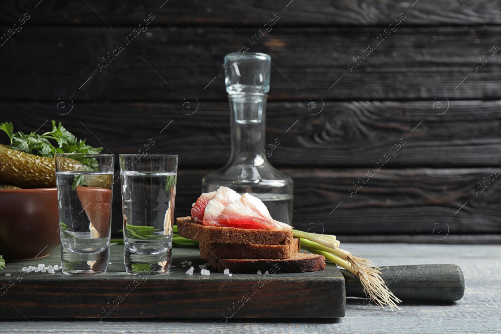 Cold Russian vodka with snacks on wooden table Photo of Cold Russian vodka with snacks on wooden table