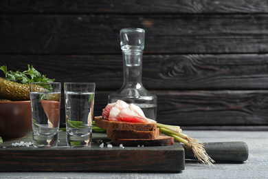 Cold Russian vodka with snacks on wooden table Photo of Cold Russian vodka with snacks on wooden table