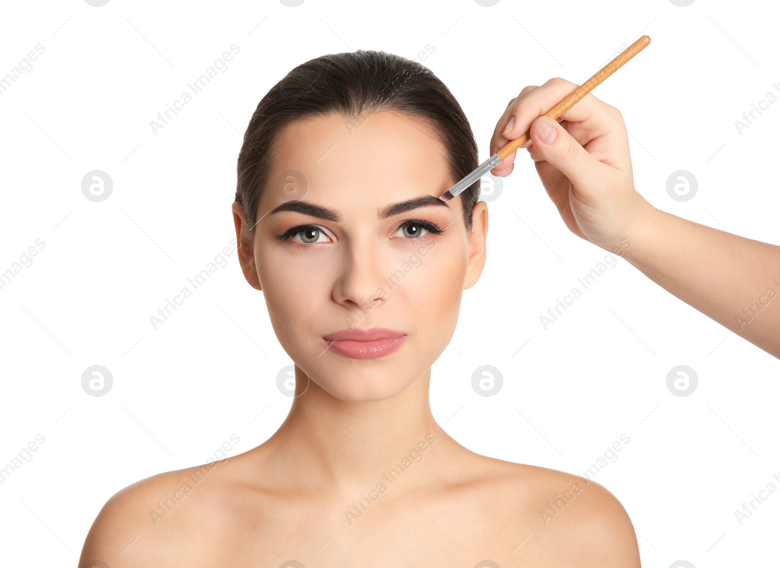 Visage artist applying makeup on woman's face against white background. Professional cosmetic products Photo of Visage artist applying makeup on woman's face against white background. Professional cosmetic products