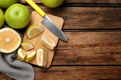Flat lay composition with whole and cut sweetie fruits on wooden table, space for text Photo of Flat lay composition with whole and cut sweetie fruits on wooden table, space for text