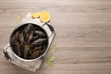 Fresh raw crayfishes in pot on wooden table, flat lay. Space for text Photo of Fresh raw crayfishes in pot on wooden table, flat lay. Space for text