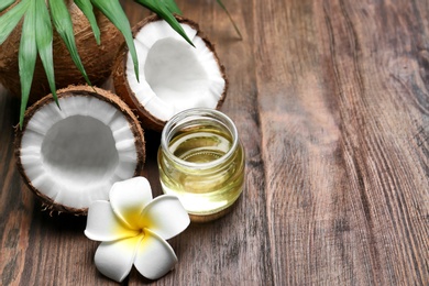 Beautiful composition with coconut oil and nuts on wooden background Photo of Beautiful composition with coconut oil and nuts on wooden background