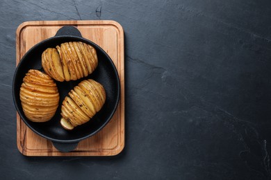 Delicious homemade Hasselback potatoes on black table, top view. Space for text Photo of Delicious homemade Hasselback potatoes on black table, top view. Space for text