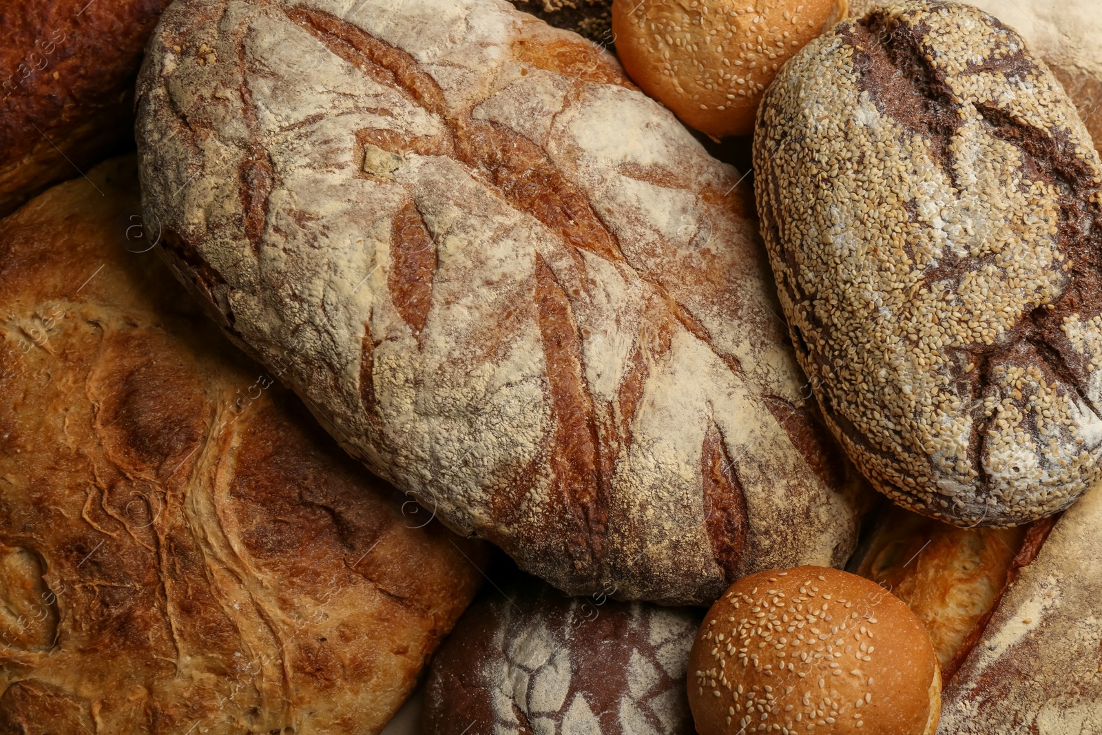Different kinds of delicious bread as background, top view Photo of Different kinds of delicious bread as background, top view