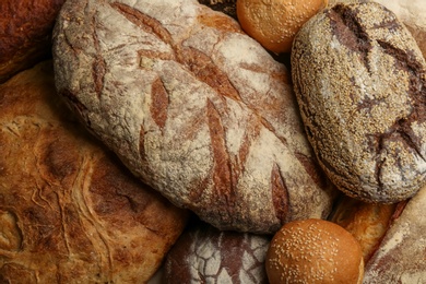 Different kinds of delicious bread as background, top view Photo of Different kinds of delicious bread as background, top view