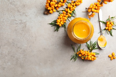 Delicious sea buckthorn jam and fresh berries on grey table, flat lay. Space for text Photo of Delicious sea buckthorn jam and fresh berries on grey table, flat lay. Space for text