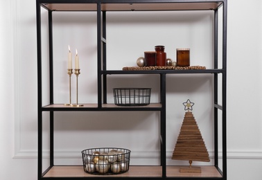 Stylish shelving unit with Christmas decor near white wall indoors. Interior design Photo of Stylish shelving unit with Christmas decor near white wall indoors. Interior design