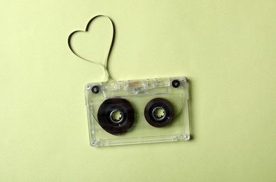 Music cassette and heart made with tape on green background, top view. Listening love song Photo of Music cassette and heart made with tape on green background, top view. Listening love song
