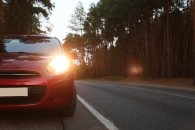 Red car parked near forest. Road trip Photo of Red car parked near forest. Road trip