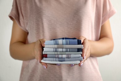 Woman holding many different handkerchiefs on white background, closeup Photo of Woman holding many different handkerchiefs on white background, closeup