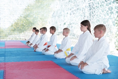 OCHAKIV, UKRAINE - JULY 09, 2020: Children in kimono sitting on tatami in pavilion. Summer camp "Sportium" Photo of OCHAKIV, UKRAINE - JULY 09, 2020: Children in kimono sitting on tatami in pavilion. Summer camp "Sportium"