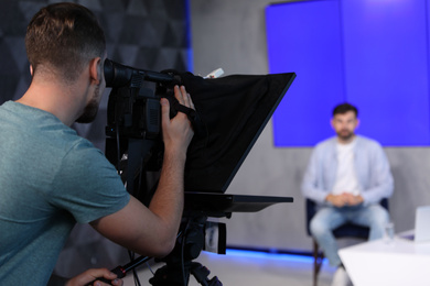 Photo of Professional video camera operator working in studio, closeup