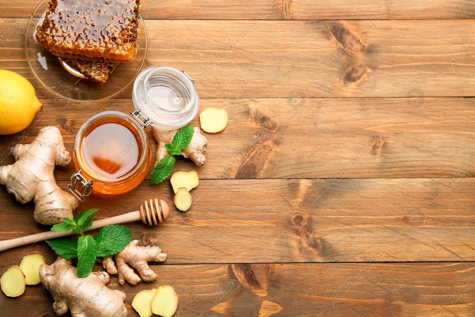 Ginger and other natural cold remedies on wooden table, flat lay. Space for text Photo of Ginger and other natural cold remedies on wooden table, flat lay. Space for text