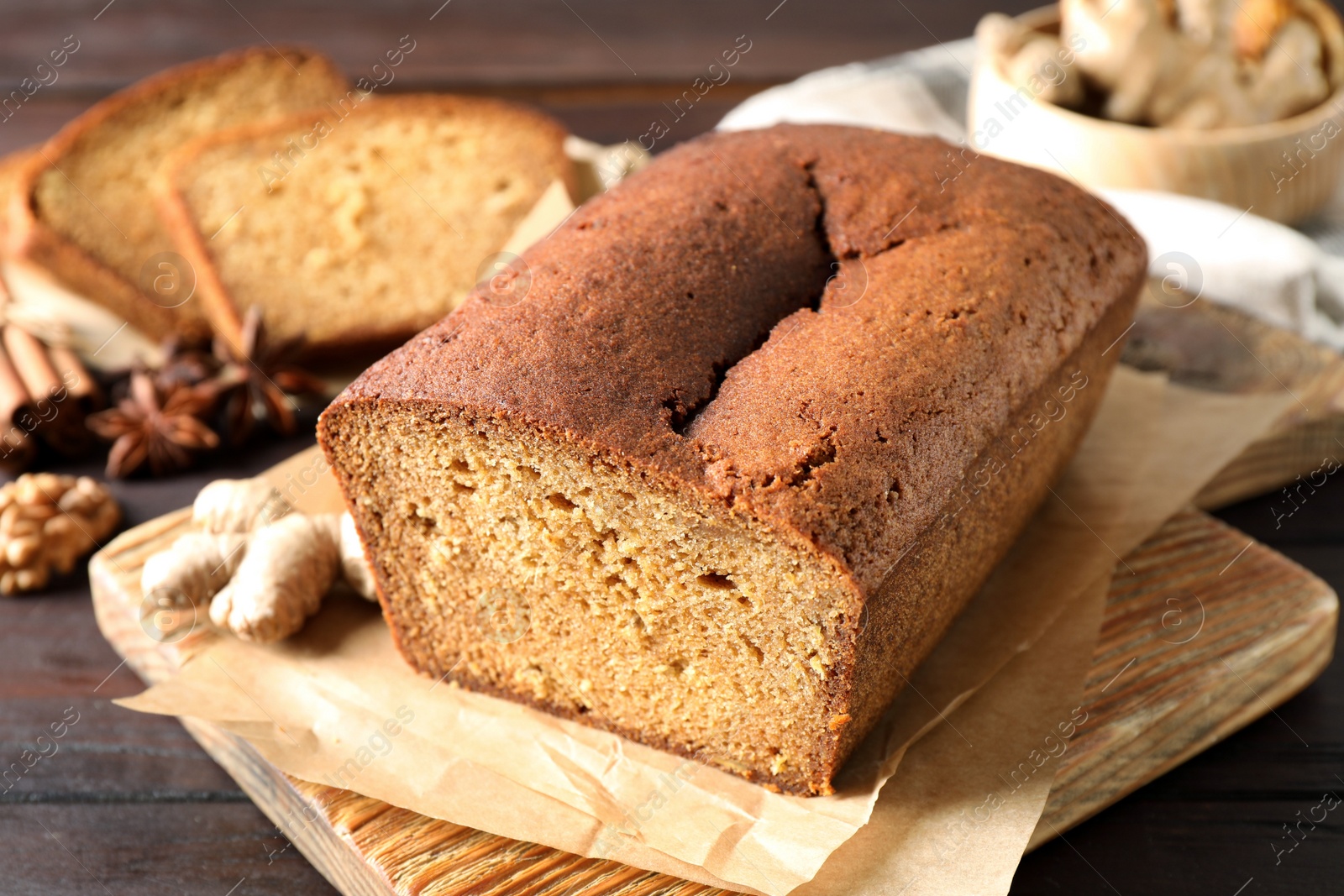 Delicious gingerbread cake and ingredients on wooden table, closeup Photo of Delicious gingerbread cake and ingredients on wooden table, closeup