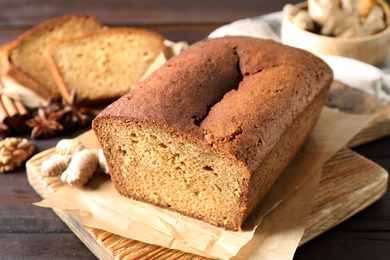 Delicious gingerbread cake and ingredients on wooden table, closeup Photo of Delicious gingerbread cake and ingredients on wooden table, closeup