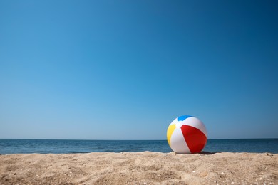 Colorful inflatable ball on sandy beach. Space for text Photo of Colorful inflatable ball on sandy beach. Space for text
