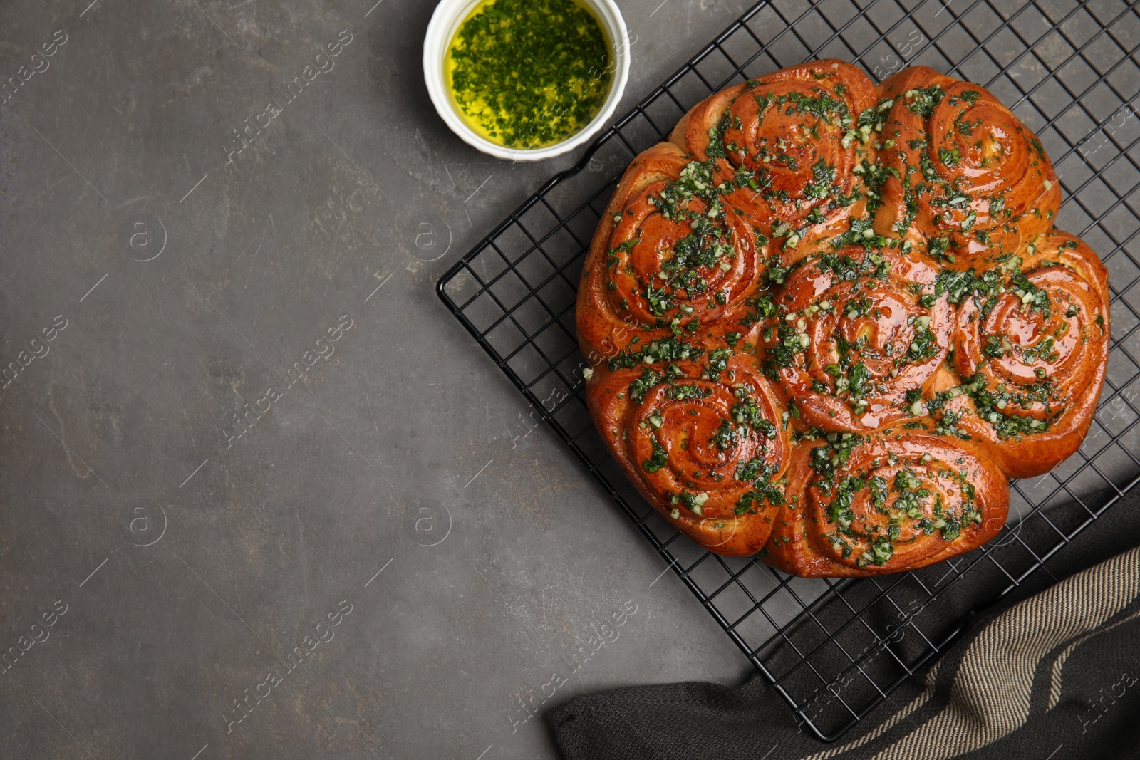Traditional Ukrainian garlic bread with herbs (Pampushky) and aromatic oil on grey table, flat lay. Space for text Photo of Traditional Ukrainian garlic bread with herbs (Pampushky) and aromatic oil on grey table, flat lay. Space for text