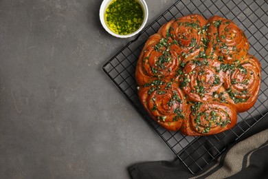 Traditional Ukrainian garlic bread with herbs (Pampushky) and aromatic oil on grey table, flat lay. Space for text Photo of Traditional Ukrainian garlic bread with herbs (Pampushky) and aromatic oil on grey table, flat lay. Space for text