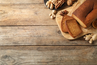 Delicious gingerbread cake and ingredients on wooden table, flat lay. Space for text Photo of Delicious gingerbread cake and ingredients on wooden table, flat lay. Space for text