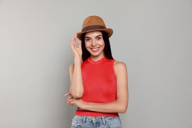 Photo of Beautiful young woman with straw hat on light grey background