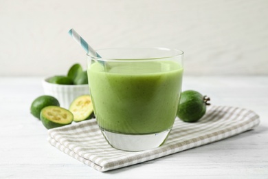 Fresh feijoa smoothie in glass on white wooden table, closeup Photo of Fresh feijoa smoothie in glass on white wooden table, closeup