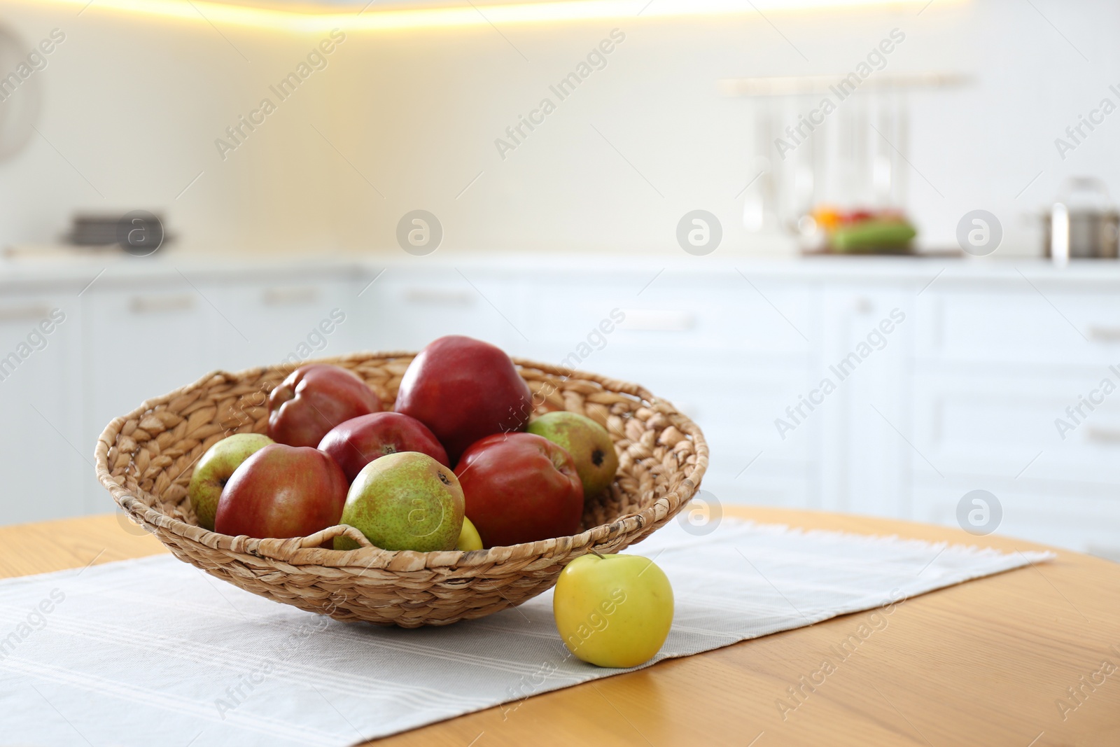 Fresh ripe apples and pears on wooden table in kitchen. Space for text Photo of Fresh ripe apples and pears on wooden table in kitchen. Space for text