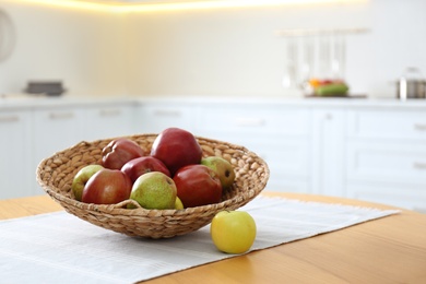 Fresh ripe apples and pears on wooden table in kitchen. Space for text Photo of Fresh ripe apples and pears on wooden table in kitchen. Space for text